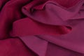 Piece of fabric lies in beautiful waves. layers of French terry pink amaranth textile