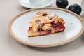 Piece of Famous Plum Torte, pie on plate on beige table. Traditional fruit cake Royalty Free Stock Photo