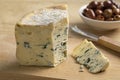 Piece of French blue Fourme d \'Ambert cheese and a on a cutting board for a snack