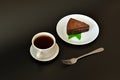 A piece of fresh chocolate cheesecake with mint on a white and round ceramic plate on a black background, next to it is a fork and Royalty Free Stock Photo