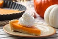 Piece of fresh homemade pumpkin pie with whipped cream on table Royalty Free Stock Photo