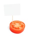 Piece of a fresh tomato with blank cardboard information tag