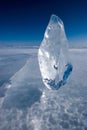 A piece of glittering ice stands on frozen Lake Baikal against a blue sky. Royalty Free Stock Photo