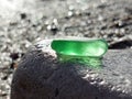 A piece of green glass on a large gray stone Royalty Free Stock Photo