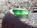 A piece of green glass on a large gray stone Royalty Free Stock Photo