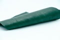 Piece of green leather and suede cut on white background. Concept and idea of fine leather crafting, handmade, handcrafted