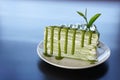 Piece of green tea crape cake on white plate and decorated with Royalty Free Stock Photo