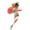 A piece of ham with olive pinned on a silver fork. Royalty Free Stock Photo