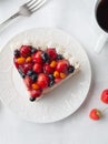 A piece of home-made cottage cheese berry pie. Garnished with cream, strawberries, blueberries, sea buckthorn berries. On a white Royalty Free Stock Photo