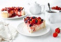 A piece of home-made cottage cheese berry pie. Garnished with cream, strawberries, blueberries, sea buckthorn berries. On a white Royalty Free Stock Photo