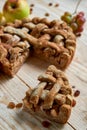 A piece of the homemade apple pie and brown raisins on light wooden background. The apple pie decorated with fresh apples Royalty Free Stock Photo