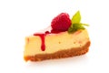 Piece of homemade cheesecake decorated with raspberries and mint on white