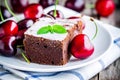 A piece of homemade chocolate brownie dessert with a cherry