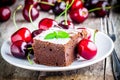 A piece of homemade chocolate brownie dessert with a cherry