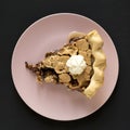 A piece of homemade Chocolate Walnut Derby Pie on a pink plate on a black background, top view. Overhead, from above, flat lay. Royalty Free Stock Photo