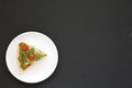 A Piece of Homemade Spinach Quiche on a white plate on a black background, top view. Flat lay, overhead, from above. Copy space Royalty Free Stock Photo