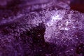 A piece of ice with frozen bubbles in the water in ultra violet
