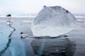 A piece of ice on the surface of the blue frozen Lake Baikal with car at background Royalty Free Stock Photo