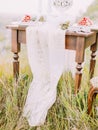 The piece of the lace table cover lying on the table and grass. Royalty Free Stock Photo