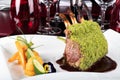 Piece of lamb rack with bone roasted with green herb, bread, sweet potatoes puree, baby vegetables Royalty Free Stock Photo