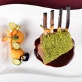 Piece of lamb rack with bone roasted with green herb, bread, sweet potatoes puree, baby vegetables Royalty Free Stock Photo