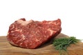 A piece of large marbled meat lies on a wooden cutting board on a white isolated background.