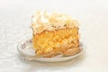 Piece of mango cake with white whipped cream and scattered almonds on top