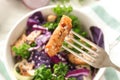 Piece of meat on fork over bowl with delicious salad, closeup Royalty Free Stock Photo