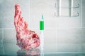 A piece of meat with a syringe with a green substance