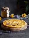 Piece of melted beeswax and glass of honey on wooden table.