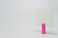 Piece of Memo paper clamped by pink wooden clip with white background and selective focus