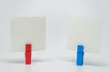Piece of Memo paper clamped by red and blue wooden clip with white background and selective focus