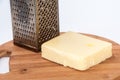 Piece of mozzarella cheese and metal grater on a kitchen wooden Royalty Free Stock Photo