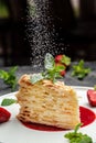 Piece of napoleon cake. Creamy vanilla swith cream, apples and strawberry jam decorated mint. Layered baked pie with powdered Royalty Free Stock Photo