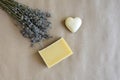 Piece of natural lavender soap, bouquet of dry lavender and small souvenir heart on craft paper. Top view, flat lay. Copy space.