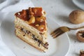 A piece of nut cake is in a plate on a light table. Royalty Free Stock Photo