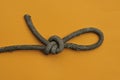 A piece of old gray dirty rope with a knot and a noose