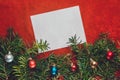 Piece of paper for Christmas wishes on a red background with branches of Christmas tree and Christmas balls Royalty Free Stock Photo