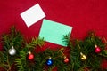 Piece of paper for Christmas wishes on a red background with branches of Christmas tree and Christmas balls Royalty Free Stock Photo