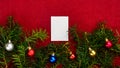 Piece of paper for Christmas wishes on a red background with branches of Christmas tree and Christmas balls Royalty Free Stock Photo