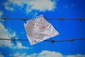 piece of paper with stop text on barbed wire on sky background Royalty Free Stock Photo