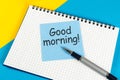 Piece of paper with text Good morning on the yellow-blue table close-up Royalty Free Stock Photo