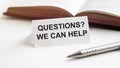 Piece of paper with text Questions We Can Help on the background of books, pens, on a white background Royalty Free Stock Photo