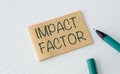 A piece of paper with the word Impact Factor written on it. A pen is sitting on the paper Royalty Free Stock Photo