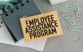 A piece of paper with the words Employee Assistance Program written on it. The paper is sitting on top of a stack of other papers. Royalty Free Stock Photo