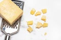 Piece of parmesan cheese on a cheese grater on a white and gray marble counter Royalty Free Stock Photo