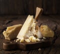 Piece of Parmesan cheese and cheese knife on the wooden board. Dark background Royalty Free Stock Photo