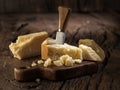 Piece of Parmesan cheese and cheese knife on the wooden board. Dark background Royalty Free Stock Photo