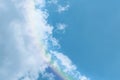 Piece of picturesque multicolored rainbow on the romantic sky. Clear afternoon day