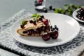 Piece of pie with blueberries, rasberry,cherries and mint for dessert on a white plate, napkin. Pieces of delicious homemade cake Royalty Free Stock Photo